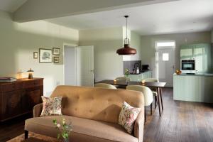 a living room and kitchen with a couch and a table at Roxburghe Cottages, part of Destination by Hyatt in Kelso