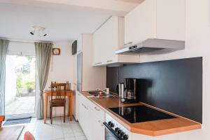 a kitchen with white cabinets and a black wall at Ferienhaus Steinhoff in Marsberg +18 photos