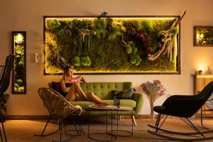 a woman sitting on a couch in a living room at Hotel la Fontaine du Mont Blanc in Les Houches