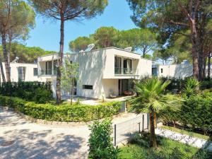 a white house with trees in front of it at Seaside Premium Villa in Lalzit Bay