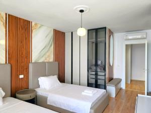a hotel room with two beds and a bathroom at Seaside Premium Villa in Lalzit Bay