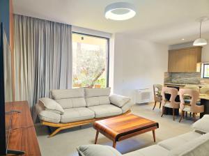 a living room with a couch and a table at Seaside Premium Villa in Lalzit Bay