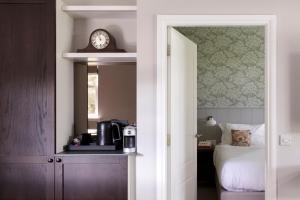 a bedroom with a bed and a clock on the wall at Roxburghe Cottages, part of Destination by Hyatt in Kelso
