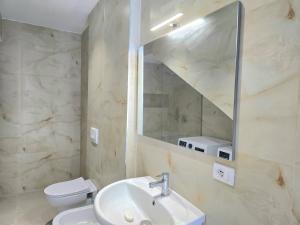 a bathroom with a sink and a toilet and a mirror at Seaside Premium Villa in Lalzit Bay +21 photos
