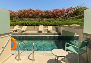 a swimming pool with chairs and a table next to a pool at Leonardo Kolymbia Resort Rhodes in Kolymbia