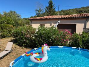 a pool with an inflatable unicorn in a yard at Maisonette paisible à La Roque-Gageac in La Roque-Gageac