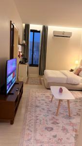 a large living room with a bed and a tv at August in Jazan