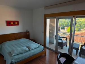 ein Schlafzimmer mit Bett und Stühlen sowie einem Balkon in der Unterkunft Hotel De Cerva in Cerva + 43 Fotos