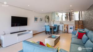 a living room with a blue couch and a tv at Emily in Vale do Lobo