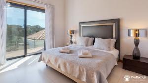 a bedroom with a large bed with two towels on it at Emily in Vale do Lobo +14 photos