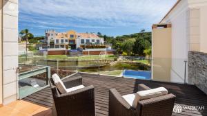 a balcony with chairs and a view of a house at Emily in Vale do Lobo