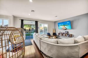a living room with a couch and a tv at Luxury and Harmony in a 6BR Dream Villa; Pool, Hot Tub, Game room, Near the Las Vegas Strip in Las Vegas