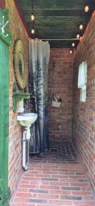 a bathroom with a sink in a brick wall at Folwark Pod Bukowcem in Podzamcze