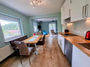 a kitchen with a wooden table and a dining room at Baker's Pond Apartment Two in Velden am Wörthersee