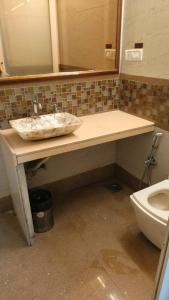 a bathroom with a sink and a toilet at Hotel Oliver in Mumbai