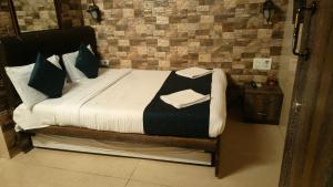 a bed with black and white sheets and pillows at Hotel Oliver in Mumbai