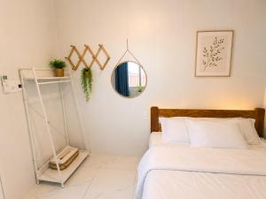 a bedroom with a bed and a mirror on the wall at SAN HÔ Beach Homestay in Thôn Ðông Giang