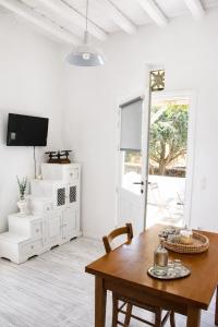 a dining room with a table and a tv at Visinokipos House in Mirsíni