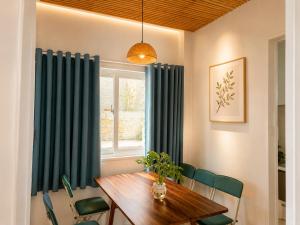 a dining room with a wooden table and green chairs at SAN HÔ Beach Homestay in Thôn Ðông Giang