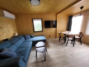 a living room with a blue couch and a table at Broumík - chata s výhledy in Opočno