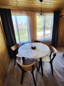 a table and chairs in a room with windows at Broumík - chata s výhledy in Opočno +9 photos