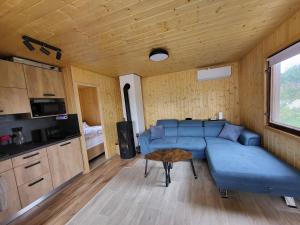 a living room with a blue couch and a table at Broumík - chata s výhledy in Opočno