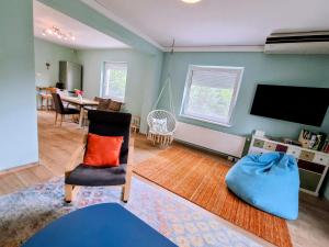a living room with a tv and a chair at Baker's Pond Apartment Two in Velden am Wörthersee