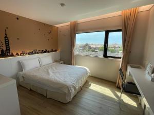 a bedroom with a bed and a large window at Hotel Taiwan Changhua in Changhua City