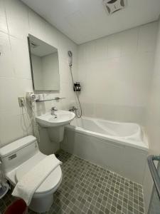 a bathroom with a toilet and a sink and a tub at Hotel Taiwan Changhua in Changhua City