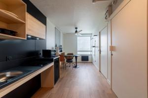 a kitchen with a sink and a table in a room at Cowool Créteil in Créteil +40 photos