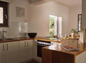 a kitchen with white cabinets and a counter with wine glasses at PanoPlagia Villa in Agios Nikolaos +12 photos