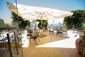 a patio with tables and chairs and an umbrella at Royal Plaza Hotel in Tiberias