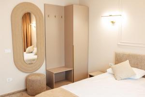 a bedroom with a bed and a mirror at Ina Deluxe in Moisei