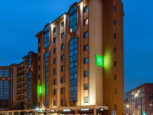 a large building with a green sign on it at Ibis Styles Toulouse Centre Canal du Midi in Toulouse
