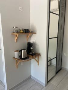 a kitchen with wooden shelves and a coffee maker on a wall at Chambre d'hôtes du Pin in Pey