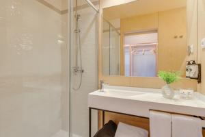 a bathroom with a sink and a shower at Pestana Dunas All Inclusive in Porto Santo +33 photos