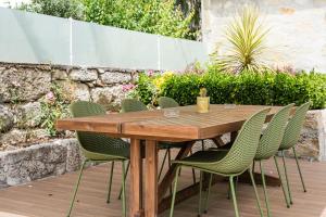 a wooden table and chairs on a patio at GuestReady - Vanzeleres Collection in Porto