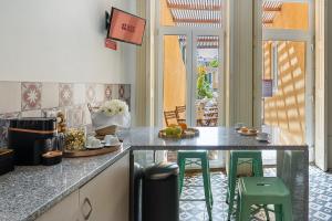 a kitchen with a counter and some green stools at GuestReady - Vanzeleres Collection in Porto