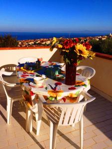 a table with a vase of flowers on a balcony at Appartamenti Del Sole in Tropea