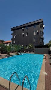 a large swimming pool in front of a building at Hotel Like Mari in P'ichvnari