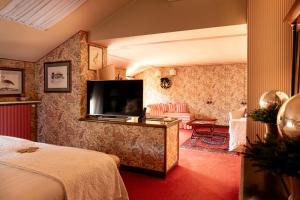 a hotel room with a bed and a television at Villa Abbazia Relais & Chateaux in Follina