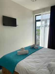 a bedroom with a large bed with towels on it at LA MĂRIUCA camere de inchiriat in Moineşti