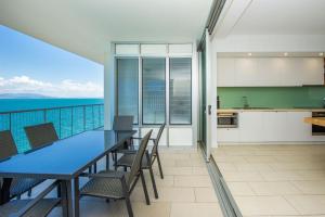 a kitchen and dining room with a view of the ocean at 1 Bright Point Apartment 5301 in Nelly Bay