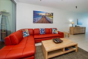 a living room with a red couch and a coffee table at 1 Bright Point Apartment 5301 in Nelly Bay