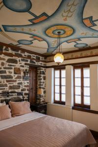 a bedroom with a bed with a painted ceiling at Archontiko Naoumidi in Portaria +170 photos