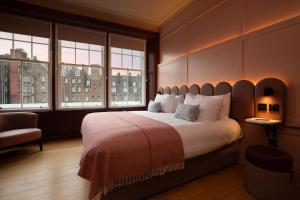 a large bedroom with a large bed with windows at The Address Wren in Glasgow