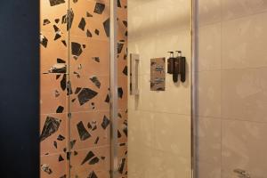 a bathroom with a shower and a phone on a wall at The Address Wren in Glasgow +15 photos