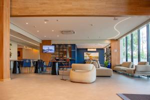 a lobby with chairs and a bar in a building at Holiday Inn Express Belem Ananindeua by IHG in Belém
