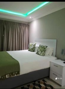 a bedroom with a large bed with a green light at Bosago lodge and Spa in Burgersfort