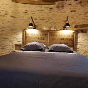 a bedroom with a large bed with two pillows at Le Moulin d' Erée, gîte Insolite de charme in Soudan
